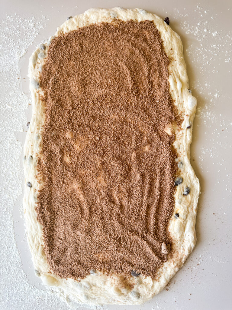 Sprinkle the cinnamon sugar filling over the top of the dough leaving a 1/2 inch border at the edge