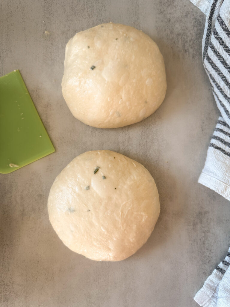 Cut dough in half and shape two round dough balls