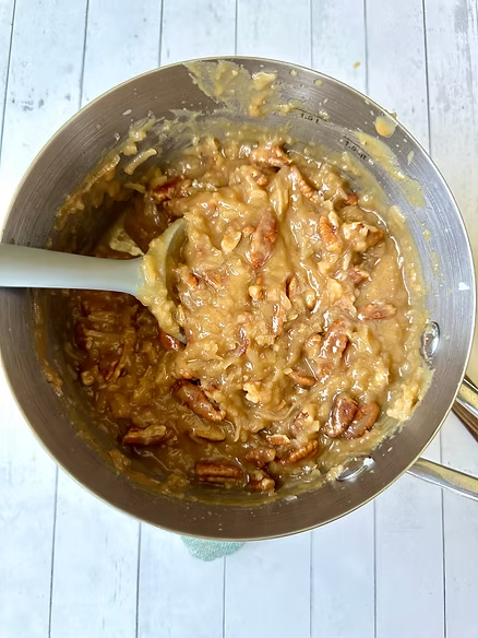 Fold pecans and coconut into frosting and allow to cool