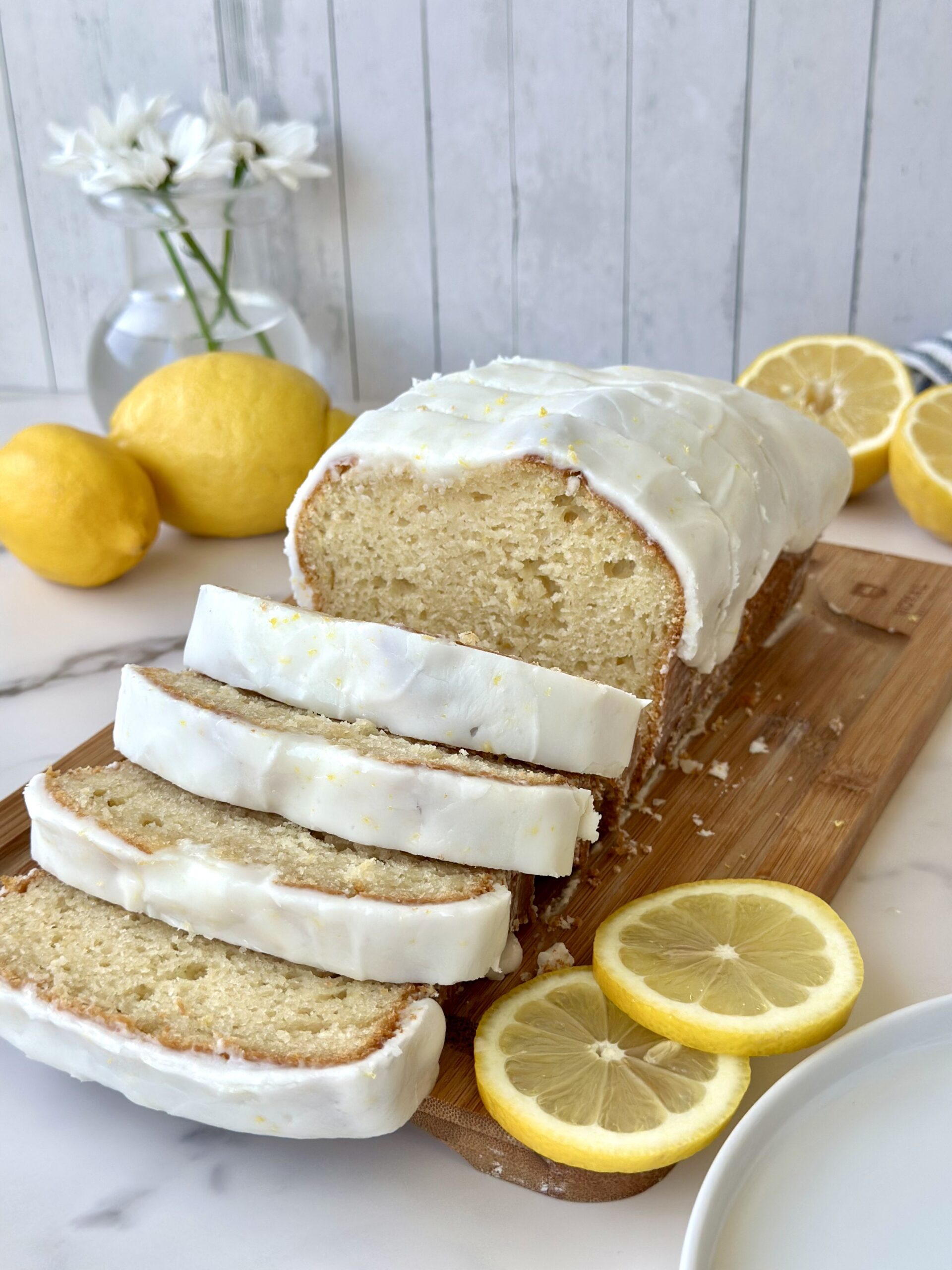 Sliced loaf of glazed lemon bread.