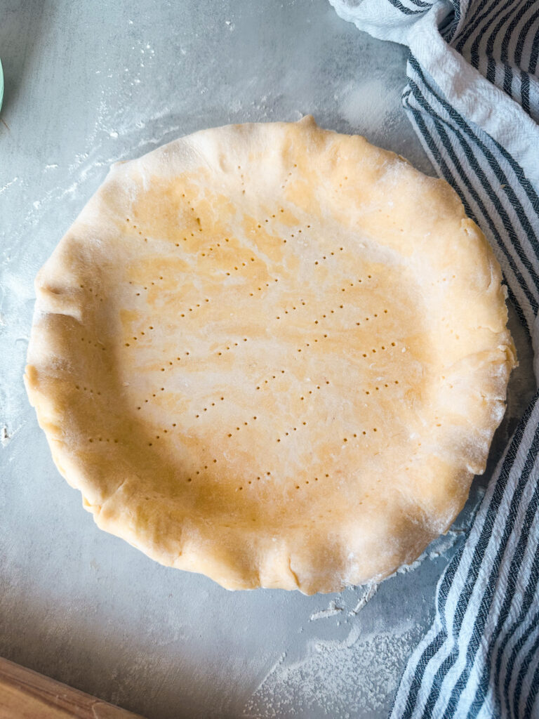 Fit pie dough into pan and dock the crust, but don't trim