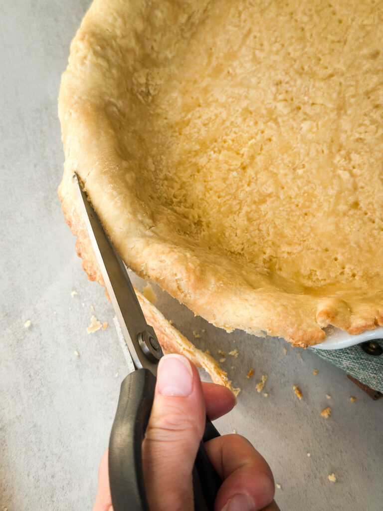 Trim the par-baked crust with scissors after it's slightly cooled so the crust is flesh with the pie pan