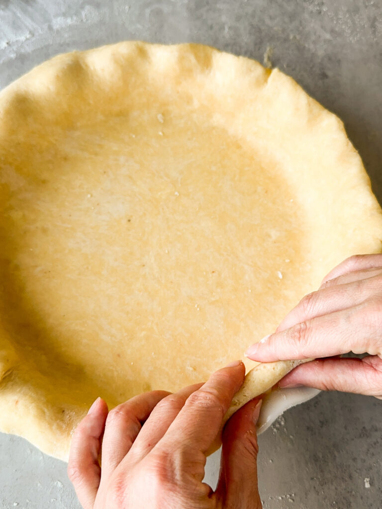 Tuck the overhang to make the crust flesh with the pie pan