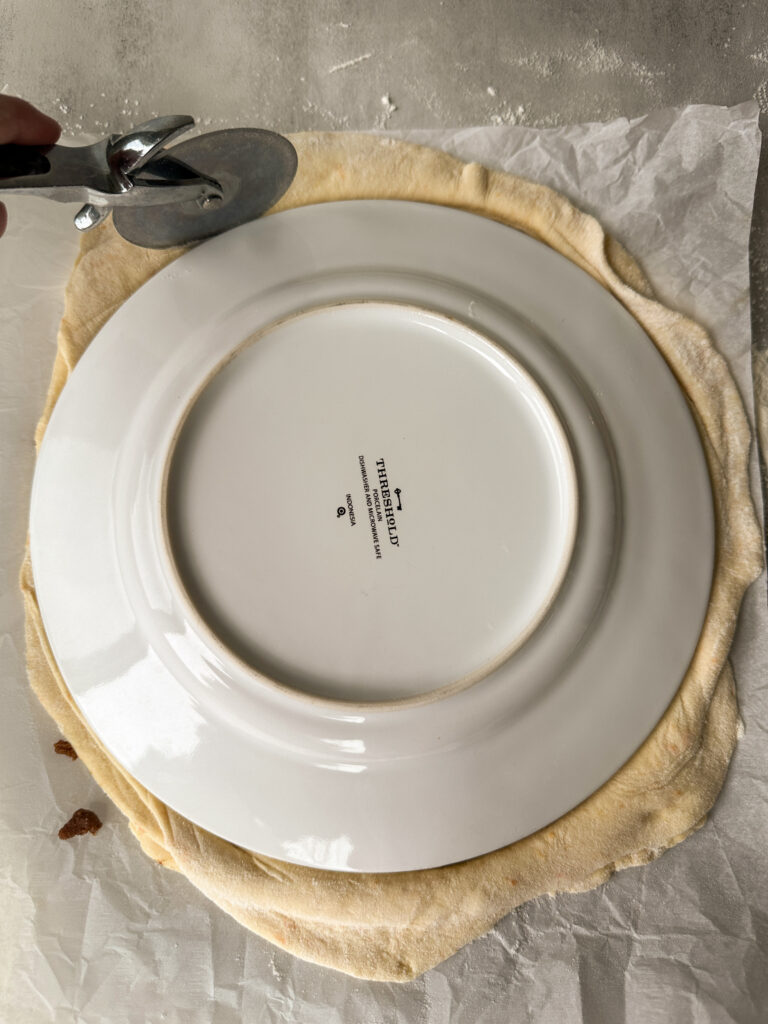 Trim the edges using a plate and pizza cutter or knife to form a clean circle 
