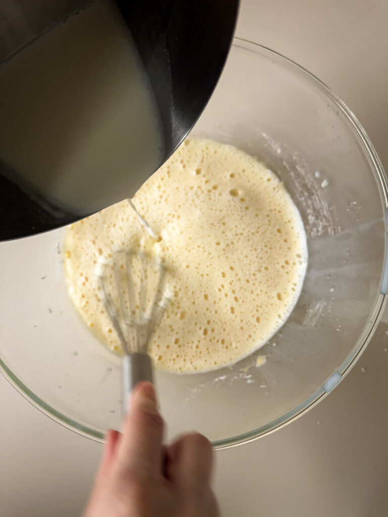 Whisk hot milk into egg mixture
