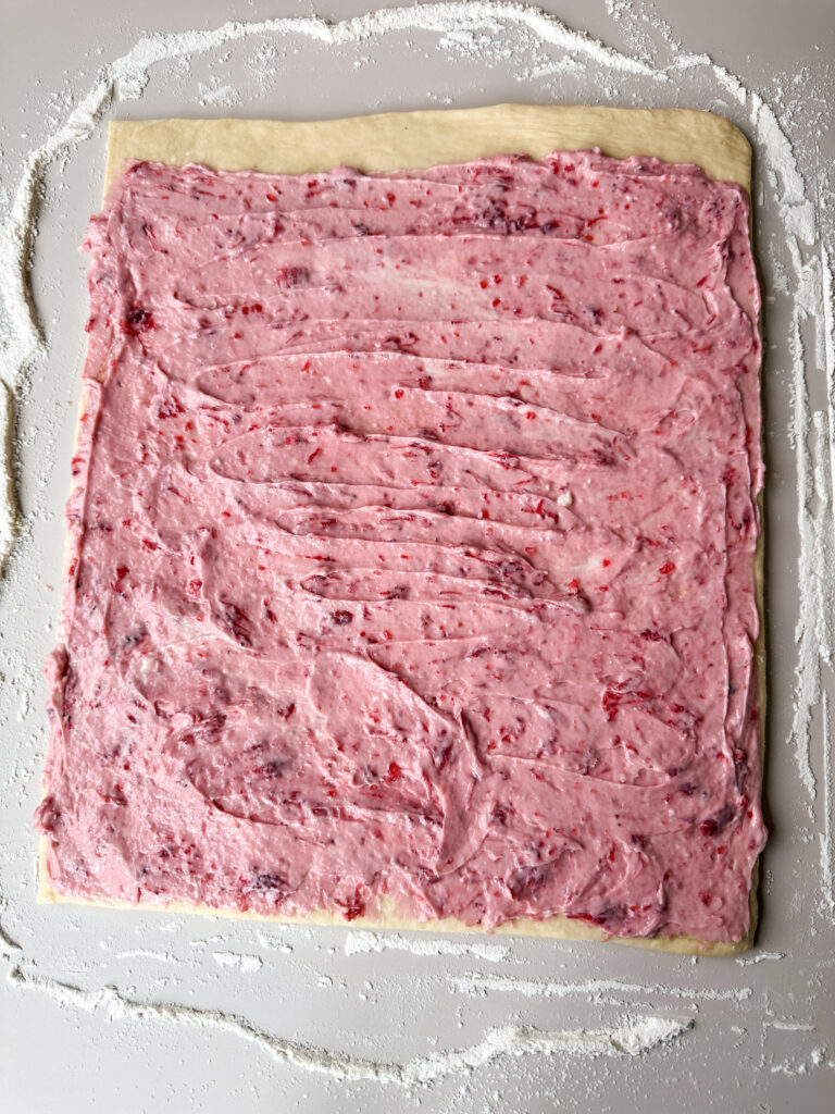 Spread strawberry filling over the top of the dough