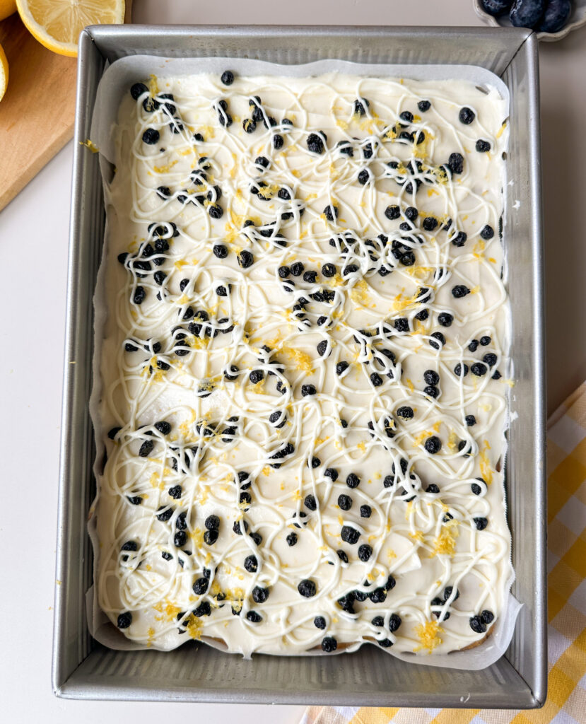Garnish the bar with the frosting, white chocolate drizzle, and more blueberries and lemon zest 