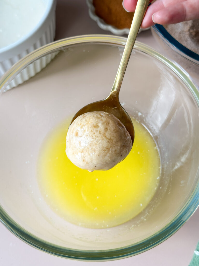 Dip donut hole in the melted butter